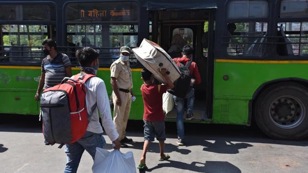 Stranded migrant workers board a transit bus to the nearest railway station. Migrants have to apply online for a seat on the Shramik Special trains after which they receive a confirmation message asking them to report to screening centres, from where DTC buses drop them to Old Delhi railway station. (Raj K Raj / HT Photo)