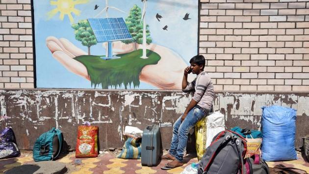 A stranded migrant worker speaks on his phone while waiting to be screened at a Delhi government school in Vinod Nagar. “It is possible many reached with forwarded messages. We are looking into the matter,” a Delhi government spokesperson told HT. (Ajay Aggarwal / HT Photo)