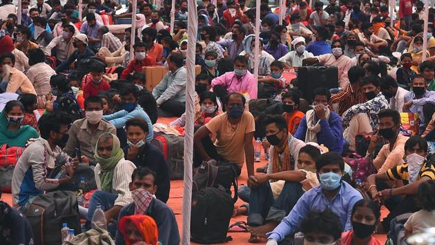 Stranded Bihar-bound migrant workers wait to be screened for body temperature inside a Delhi government school in Vinod Nagar, before being taken to board Shramik Special trains to their homes. (Raj K Raj / HT Photo)