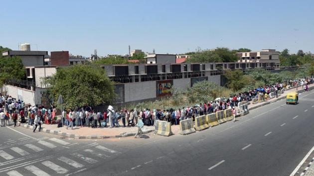 Migrant workers queue outside a Delhi Government school for screening before leaving for the railway station. At the school in Vinod Nagar, the queue of migrant workers was visible until the evening. While some of them were waiting for their turn since last night, many reached as early as 4am on May 20. (Ajay Aggarwal / HT Photo)