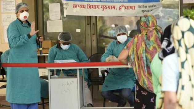 A doctor gestures at visitors queuing at a special Covid-19 help desk, amid the lockdown, in Civil Hospital, Sector-10, Gurugram, India, on Saturday, 16 May 2020.(Parveen Kumar/Hindustan Times)