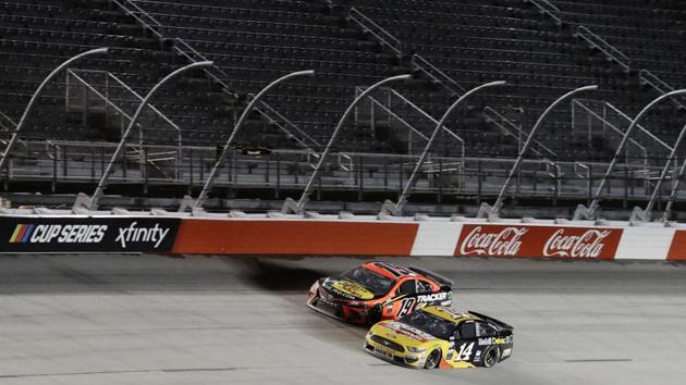 Martin Truex Jr. (19) and Clint Bowyer (14) battle during the NASCAR Cup Series auto race. (AP)