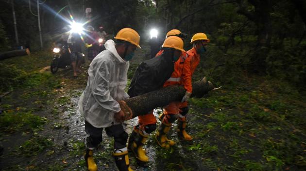 Members of National Disaster Response Force (NDRF) remove a branch of an uprooted tree after Cyclone Amphan made its landfall, in West Bengal’s Digha, on Wednesday.(Reuters Photo) Members of National Disaster Response Force (NDRF) remove a branch of an uprooted tree after Cyclone Amphan made its landfall, in West Bengal’s Digha, on Wednesday.(Reuters Photo)