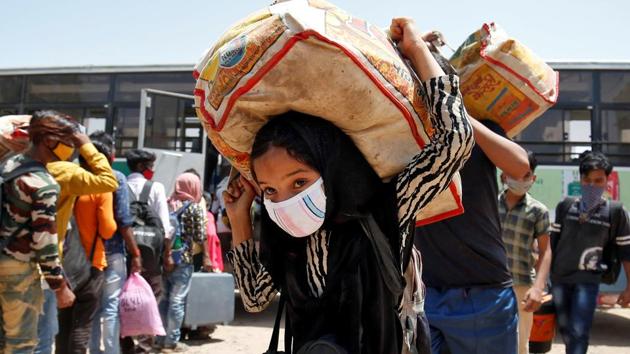 A girl carrying her belongings walks with her family members to get token to board a train to their home state of eastern Bihar, during an extended lockdown to slow the spreading of the coronavirus disease (Covid-19), in Ahmedabad, India, May 20, 2020.(Reuters file photo)