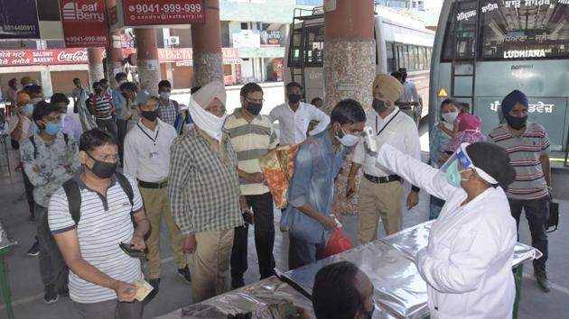 A health department official carrying out thermal screening of a passengers before giving them tickets for Barnala, at the Ludhiana bus stand Wednesday. (Gurpreet Singh/HT) A health department official carrying out thermal screening of a passengers before giving them tickets for Barnala, at the Ludhiana bus stand Wednesday. (Gurpreet Singh/HT)