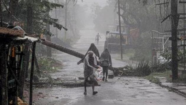 People make way through gusty winds as super cyclone Amphan makes landfall, near Dhamara Port in Bhadrak district, Wednesday, May 20, 2020.(PTI) People make way through gusty winds as super cyclone Amphan makes landfall, near Dhamara Port in Bhadrak district, Wednesday, May 20, 2020.(PTI)