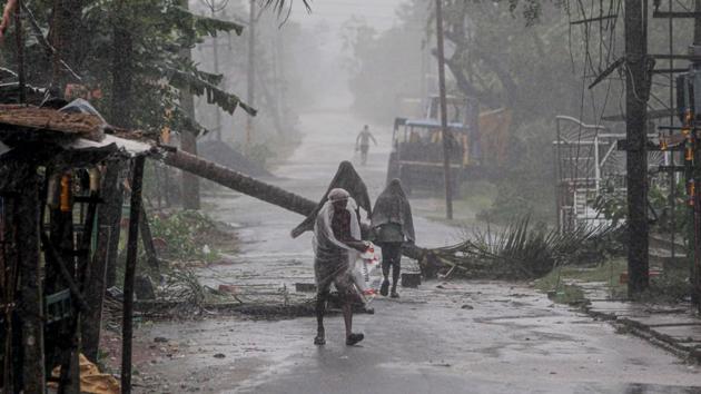 People make way through gusty winds as super cyclone Amphan makes landfall, near Dhamara Port in Bhadrak district, Wednesday, May 20, 2020. (PTI photo) People make way through gusty winds as super cyclone Amphan makes landfall, near Dhamara Port in Bhadrak district, Wednesday, May 20, 2020. (PTI photo)