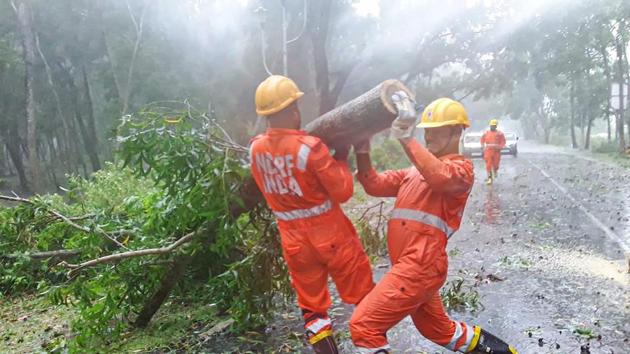 NDRF personnel clear uprooted trees from a road following gusty winds after Cyclone Amphan’s landfall in Ramnagar, Purba Medinipur, West Bengal on May 20. Some reports mentioned that 5,500 houses were damaged in one district of West Bengal. (PTI)