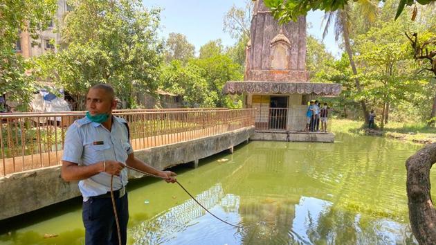 Fire brigade personnel said they will drain out the pond water to find the missing people. (HT) Fire brigade personnel said they will drain out the pond water to find the missing people. (HT)