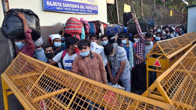 Stranded migrant workers queue outside Rajkiya Sarvodaya Bal Vidyalaya for transit buses to ferry them to the railway station amid the lockdown, in West Vinod Nagar, in New Delhi, India, on Thursday, May 21, 2020.(Ajay Aggarwal /HT PHOTO)