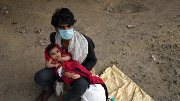 A migrant worker with his four month old daughter at Ghazipur border, in New Delhi. (Ajay Aggarwal /HT PHOTO) A migrant worker with his four month old daughter at Ghazipur border, in New Delhi. (Ajay Aggarwal /HT PHOTO)