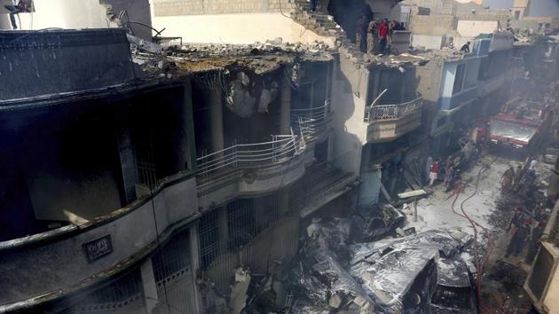 Fire brigade staff try to put out fire caused by a plane crash in Karachi, Pakistan(AP)