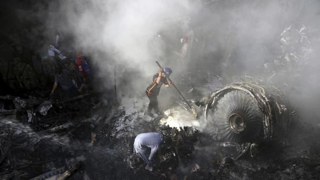 Volunteers look for survivors of a plane that crashed in residential area of Karachi, Pakistan, May 22, 2020.(AP)