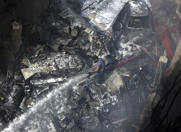 A firefighter tries to put out fire caused by PK-8330 Pakistan International Airline (PIA) aircraft crash in Karachi, Pakistan, Friday, May 22, 2020.(AP)