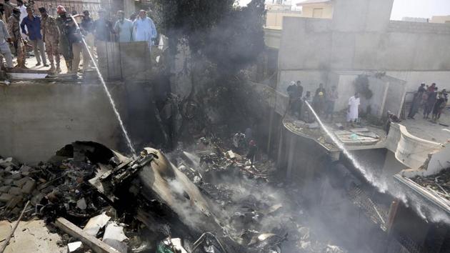 Fire brigade staff try to put out fire caused by plane crash in Karachi, Pakistan on Friday.(AP Photo)