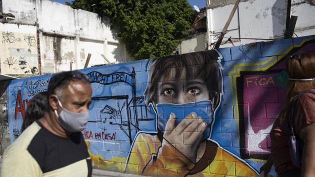 A man walks past a mural referencing the COVID-19 pandemic, painted in honor of health workers in Rio de Janeiro, Brazil, Thursday, May 21, 2020.(AP) A man walks past a mural referencing the COVID-19 pandemic, painted in honor of health workers in Rio de Janeiro, Brazil, Thursday, May 21, 2020.(AP)