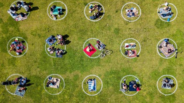 People gathered inside circles painted on the grass encouraging social distancing at Dolores Park in San Francisco, California on May 22. Americans are fleeing weeks of home isolation for beaches, parks and other leisure destinations over the Memorial Day weekend -- and that has pandemic experts and businesses concerned about a spike in coronavirus cases. (Josh Edelson / AFP)