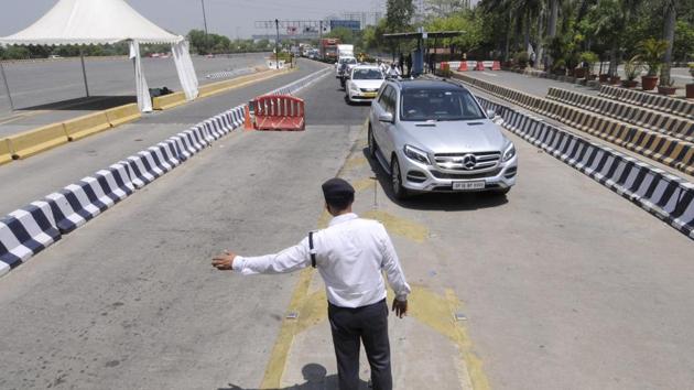 Uttar Pradesh trafic police personnel screening commuters at the DND toll plaza along Uttar Pradesh-Delhi border during lockdown in Noida.(Sunil Ghosh / Hindustan Times)