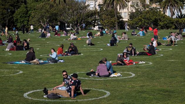 People lay on the grass at Dolores Park in San Francisco. The holiday arrives amid the bleakest economy in decades. Tens of millions have been laid off since the virus hit hard in March and forced shutdowns. Unemployment has reached its highest level since the Great Depression. (David Paul Morris / Bloomberg)