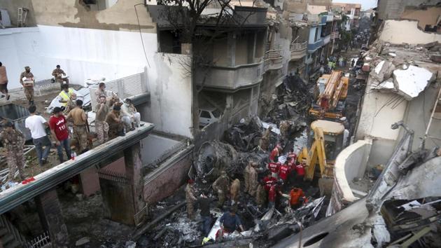 Volunteers and soldiers look for survivors of a plane crash in a residential area of Karachi, Pakistan.(AP)