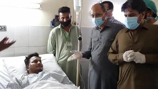 Pakistani provincial minister Saeed Ghani, second from right, meets Mohammad Zubair who survived a plane crash, at a hospital in Karachi, Pakistan, Friday, May 22, 2020.(AP)