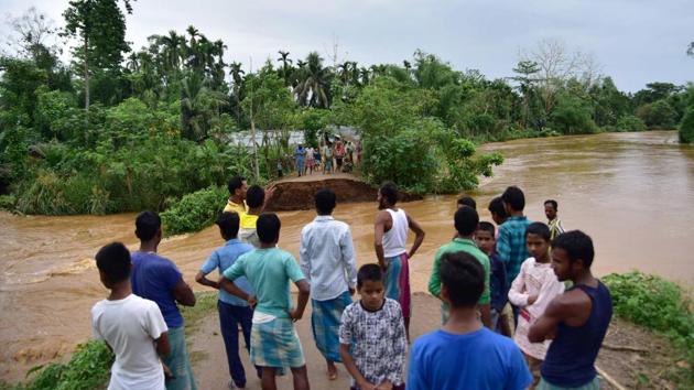 Nagaon: Villagers watch a washed away road after flooding by Borpani River due to incessant rainfall for the past two days at Madhab Para near Kampur in Nagaon district of Assam on Friday.(PTI Photo)