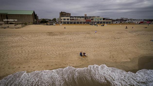 Beach goers seen at Asbury Park, New Jersey. Jersey Shore beaches will be open but there will be no fireworks, Ferris wheel rides, roller coasters, go-karts or arcade games. (Christopher Occhicone / Bloomberg)
