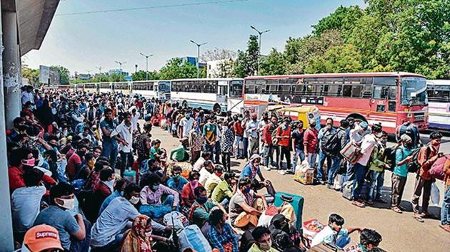 Migrant workers and families wait for transportation at the Ahmedabad railway station on Saturday. Migrant workers and families wait for transportation at the Ahmedabad railway station on Saturday.