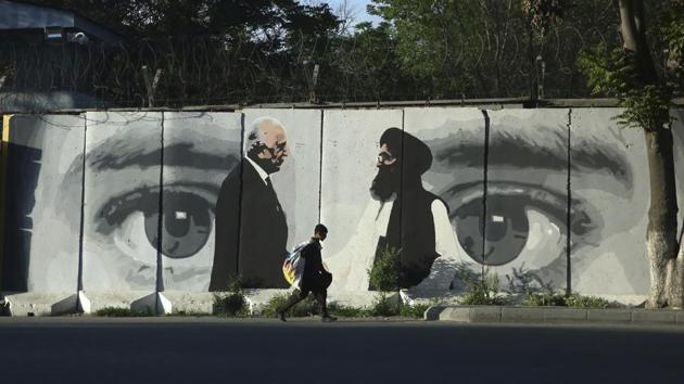 A young boy carries a sack of goods on his back walks past a wall depicting Washington's peace envoy Zalmay Khalilzad, left, and Mullah Abdul Ghani Baradar, the leader of the Taliban delegation, in Kabul, Afghanistan. (AP/ File photo) A young boy carries a sack of goods on his back walks past a wall depicting Washington's peace envoy Zalmay Khalilzad, left, and Mullah Abdul Ghani Baradar, the leader of the Taliban delegation, in Kabul, Afghanistan. (AP/ File photo)