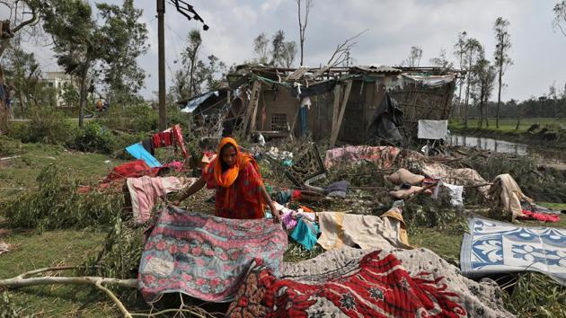 A woman spreads quilts and sheets for drying after salvaging them from the rubble of her damaged house in the aftermath of Cyclone Amphan, in South 24 Parganas district. (Rupak De Chowdhuri / REUTERS) A woman spreads quilts and sheets for drying after salvaging them from the rubble of her damaged house in the aftermath of Cyclone Amphan, in South 24 Parganas district. (Rupak De Chowdhuri / REUTERS)