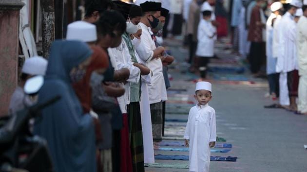 A boy stands as his parents perform an Eid al-Fitr prayer marking the end of the holy fasting month of Ramadan amid concerns of the new coronavirus outbreak in Jakarta, Indonesia, Sunday, May 24, 2020. (AP) A boy stands as his parents perform an Eid al-Fitr prayer marking the end of the holy fasting month of Ramadan amid concerns of the new coronavirus outbreak in Jakarta, Indonesia, Sunday, May 24, 2020. (AP)