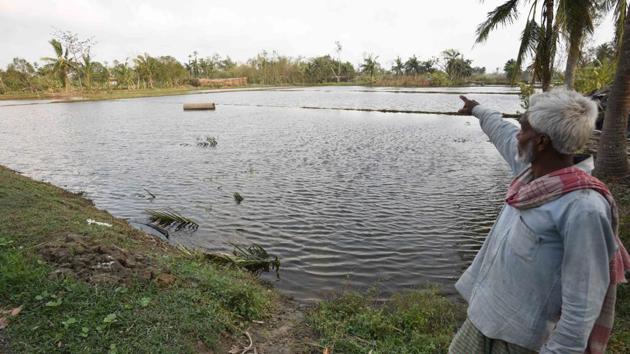 A man points towards a pond filled with saline water due to Cyclone Amphan. Chief Secretaries of Odisha and West Bengal informed the National Crisis Management Committee (NCMC) that timely and accurate forecast by the IMD and advance deployment of NDRF facilitated the evacuation of about 5 lakh people in West Bengal. (Samir Jana / HT Photo) A man points towards a pond filled with saline water due to Cyclone Amphan. Chief Secretaries of Odisha and West Bengal informed the National Crisis Management Committee (NCMC) that timely and accurate forecast by the IMD and advance deployment of NDRF facilitated the evacuation of about 5 lakh people in West Bengal. (Samir Jana / HT Photo)