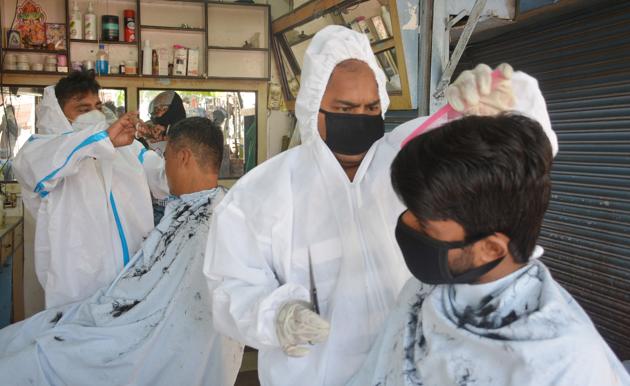 Hairdressers in Sector 11 rehri market in Panchkula offering services wearing protective gears on Sunday. (Sant Arora/Hindustan Times) Hairdressers in Sector 11 rehri market in Panchkula offering services wearing protective gears on Sunday. (Sant Arora/Hindustan Times)