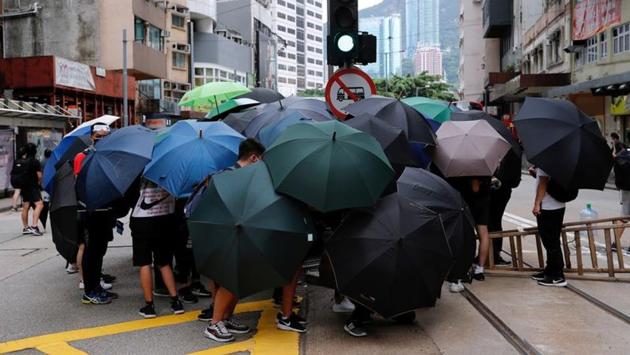 Anti-government protesters set up roadblocks under umbrellas. Hong Kong took to the streets after China said it will introduce a law to prevent and punish any acts of secession, subversion or terrorism in the city that threaten national security. (Tyrone Siu / REUTERS) Anti-government protesters set up roadblocks under umbrellas. Hong Kong took to the streets after China said it will introduce a law to prevent and punish any acts of secession, subversion or terrorism in the city that threaten national security. (Tyrone Siu / REUTERS)