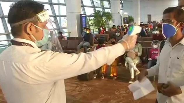 A passenger gets his temperature checked before boarding a flight from Delhi airport on Monday morning. (ANI Photo) A passenger gets his temperature checked before boarding a flight from Delhi airport on Monday morning. (ANI Photo)