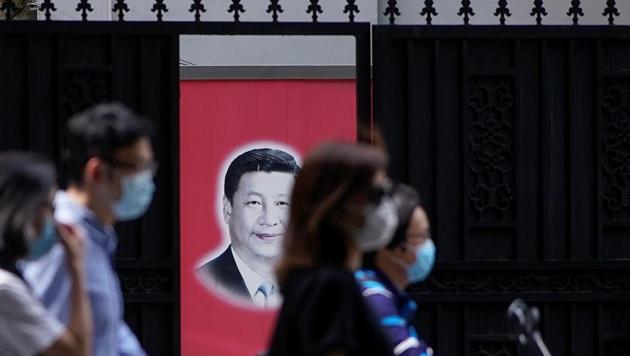 People wearing masks are seen in front of a portrait of Chinese President Xi Jinping on a street on the opening day of the National People's Congress (NPC), in Shanghai, China.(REUTERS) People wearing masks are seen in front of a portrait of Chinese President Xi Jinping on a street on the opening day of the National People's Congress (NPC), in Shanghai, China.(REUTERS)