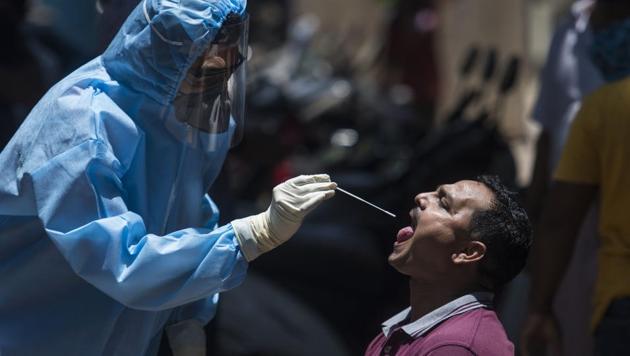 A doctor takes a swab sample of a resident during a coronavirus testing drive inside the Dharavi slums in Mumbai. (Pratik Chorge/HT Photo) A doctor takes a swab sample of a resident during a coronavirus testing drive inside the Dharavi slums in Mumbai. (Pratik Chorge/HT Photo)