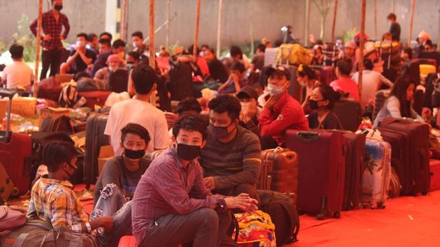 Migrants wait at Tau Devi Lal Stadium to be screened and sent to board a Dimapur via Guwahati Shramik Special train, in Gurugram, on Friday.(Yogendra Kumar/HT Photo)