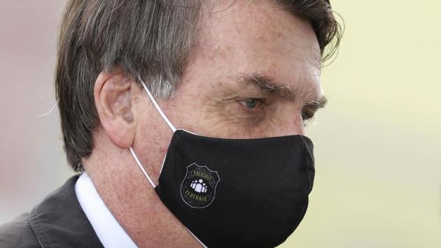 Brazil’s President Jair Bolsonaro faces supporters while departing his official residence of Alvorada palace in Brasilia. Bolsonaro on May 24 hailed supporters rallying in the country’s capital to back his administration. He was seen posing for photographs, shaking people’s hands and even carrying a young boy on his shoulders, part of a pattern of flouting and discouraging social isolation measures advised by health professionals. (AP / PTI) Brazil’s President Jair Bolsonaro faces supporters while departing his official residence of Alvorada palace in Brasilia. Bolsonaro on May 24 hailed supporters rallying in the country’s capital to back his administration. He was seen posing for photographs, shaking people’s hands and even carrying a young boy on his shoulders, part of a pattern of flouting and discouraging social isolation measures advised by health professionals. (AP / PTI)
