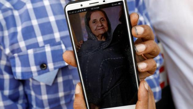 Shahid Ahmed holds his mobile phone displaying photo of his mother Irshad Begum, 72, who was killed in a plane crash, outside a morgue in Karachi, Pakistan.(Reuters)