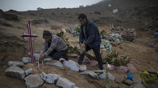 Siblings Julia and Jorge Lopez decorate the burial site of their mother, who recently died from coronavirus, at a public cemetery in Lima, Peru. Peru has reported 11,959 cases and 3,456 deaths due to the virus. (Rodrigo Abd / AP) Siblings Julia and Jorge Lopez decorate the burial site of their mother, who recently died from coronavirus, at a public cemetery in Lima, Peru. Peru has reported 11,959 cases and 3,456 deaths due to the virus. (Rodrigo Abd / AP)