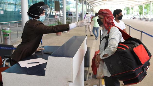 A traveller is thermal screened before being allowing into Sri Guru Ramdas Jee International Airport in Amritsar. Union civil aviation minister Hardeep Singh Puri said 532 flights carried 39,231 passengers on the first day of the resumption of operations. (Sameer Sehgal / HT Photo)