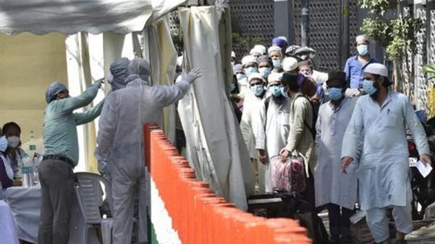 People who took part in a Tablighi Jamaat event in March are checked by a health team before being taken to a quarantine facility in this file photo.(Ajay Aggarwal/HT Photo)