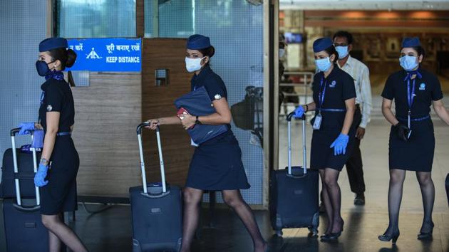Flight attendants wearing face shields walk out of the Sardar Vallabhbhai Patel International Airport, in Ahmedabad on May 25. (SAM PANTHAKY / AFP)
