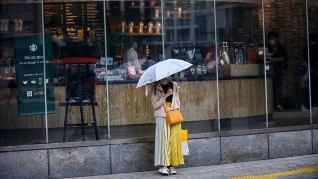 A woman wearing a facemask stands outside an opened Starbucks cafe in the Shibuya district of Tokyo on May 26. Prime Minister Abe had declared an emergency in the capital and some other areas from April 7, later expanding it nationwide. From mid-May he began lifting it in places where the rate of new infections subsided. (Behrouz Mehri / AFP) A woman wearing a facemask stands outside an opened Starbucks cafe in the Shibuya district of Tokyo on May 26. Prime Minister Abe had declared an emergency in the capital and some other areas from April 7, later expanding it nationwide. From mid-May he began lifting it in places where the rate of new infections subsided. (Behrouz Mehri / AFP)