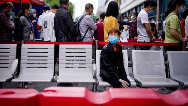 File picture of a woman wearing a face mask looking on in front of others standing in a queue for nucleic acid testings in Wuhan, the Chinese city hit hardest by the coronavirus disease on May 16, 2020. (Reuters) File picture of a woman wearing a face mask looking on in front of others standing in a queue for nucleic acid testings in Wuhan, the Chinese city hit hardest by the coronavirus disease on May 16, 2020. (Reuters)