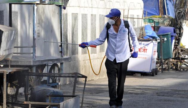A Noida Authority personnel disinfects an area in a coronavirus hotspot at Sector 9, in Noida, India, on Monday, May 25, 2020.(Sunil Ghosh / Hindustan Times)