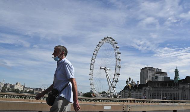 A man wearing a protective mask strolls across a bridge in central London, Tuesday, May 26, 2020, during hot weather following the gradual easing of the COVID-19 lockdown, allowing more outdoor recreation and letting some shops and businesses reopen. (AP) A man wearing a protective mask strolls across a bridge in central London, Tuesday, May 26, 2020, during hot weather following the gradual easing of the COVID-19 lockdown, allowing more outdoor recreation and letting some shops and businesses reopen. (AP)