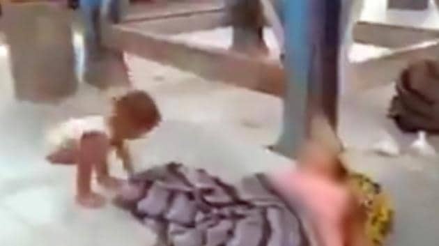 A video tweeted by Sanjay Yadav, an aide to RJD leader Tejashwi Yadav, shows the child walking unsteadily up to his mother’s body, tugging at the blanket placed over her, and when failing to wake her up, covering his own head with it.(Screengrab from the video) A video tweeted by Sanjay Yadav, an aide to RJD leader Tejashwi Yadav, shows the child walking unsteadily up to his mother’s body, tugging at the blanket placed over her, and when failing to wake her up, covering his own head with it.(Screengrab from the video)