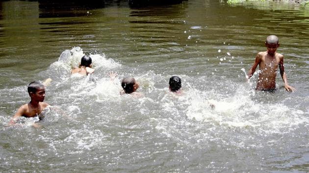 Children take bath in the Yamuna river during the heatwave in New Delhi on Tuesday.(ANI Photo)